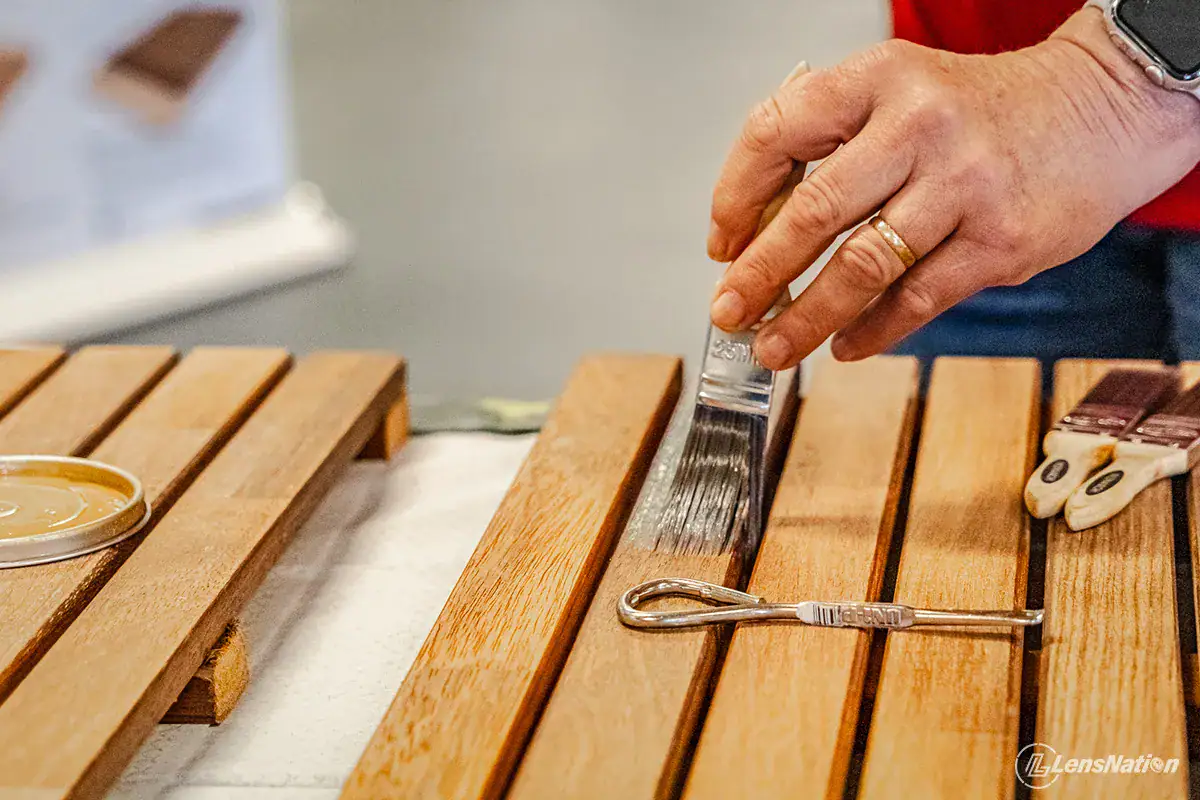 Hands applying Sikkens paint in workshop setting