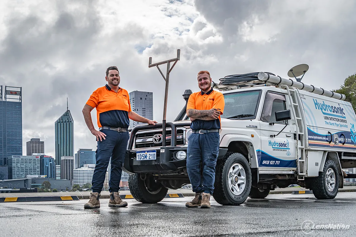Close-up of branded plumbing vehicle with Perth skyline visible behind