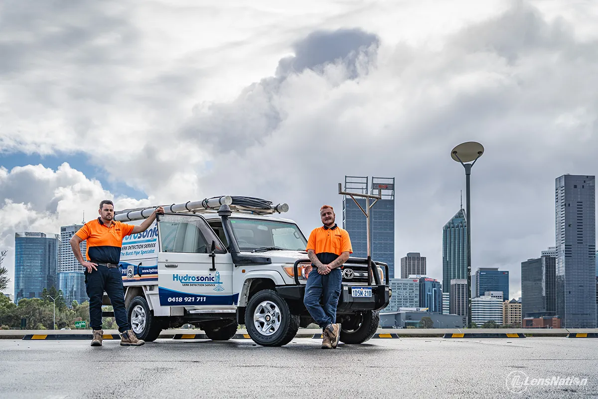 Wide angle shot of plumbing service van with Perth skyline across the Swan River