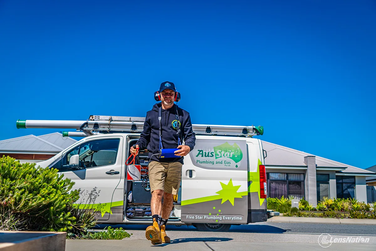 Plumber walking towards a house in front of his service van Photography perth